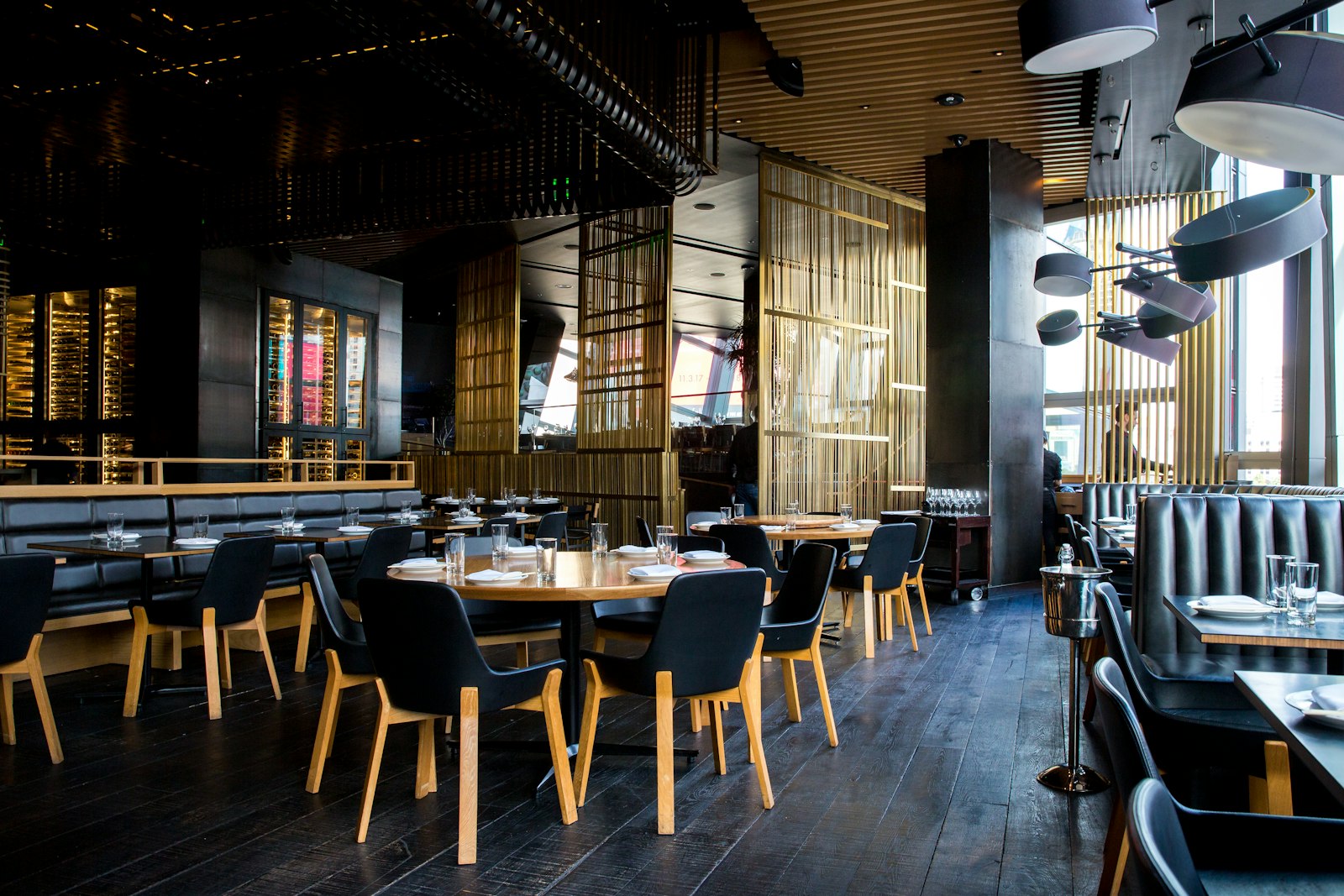Dining room with dark wood, leather seating and gold screens
